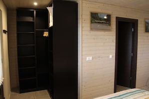 Een slaapkamer met een bed, een kledingkast en een deur.