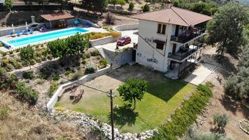 Ein zweistöckiges Haus mit Swimmingpool, Balkon und Garten.
