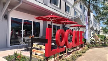 A building with large red letters spelling "LOCALE" and signs indicating "LOCALE," "Urban Kitchen," and "Parking at the Rear."