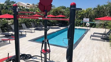 A poolside area with a diving board, lounge chairs, and a sign indicating no diving.