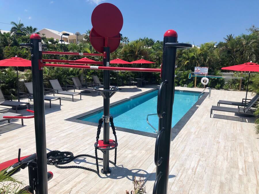 A poolside area with a diving board, lounge chairs, and a sign indicating no diving.