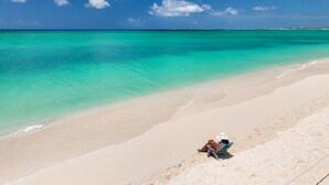 Una playa con aguas turquesas cristalinas y una orilla arenosa.