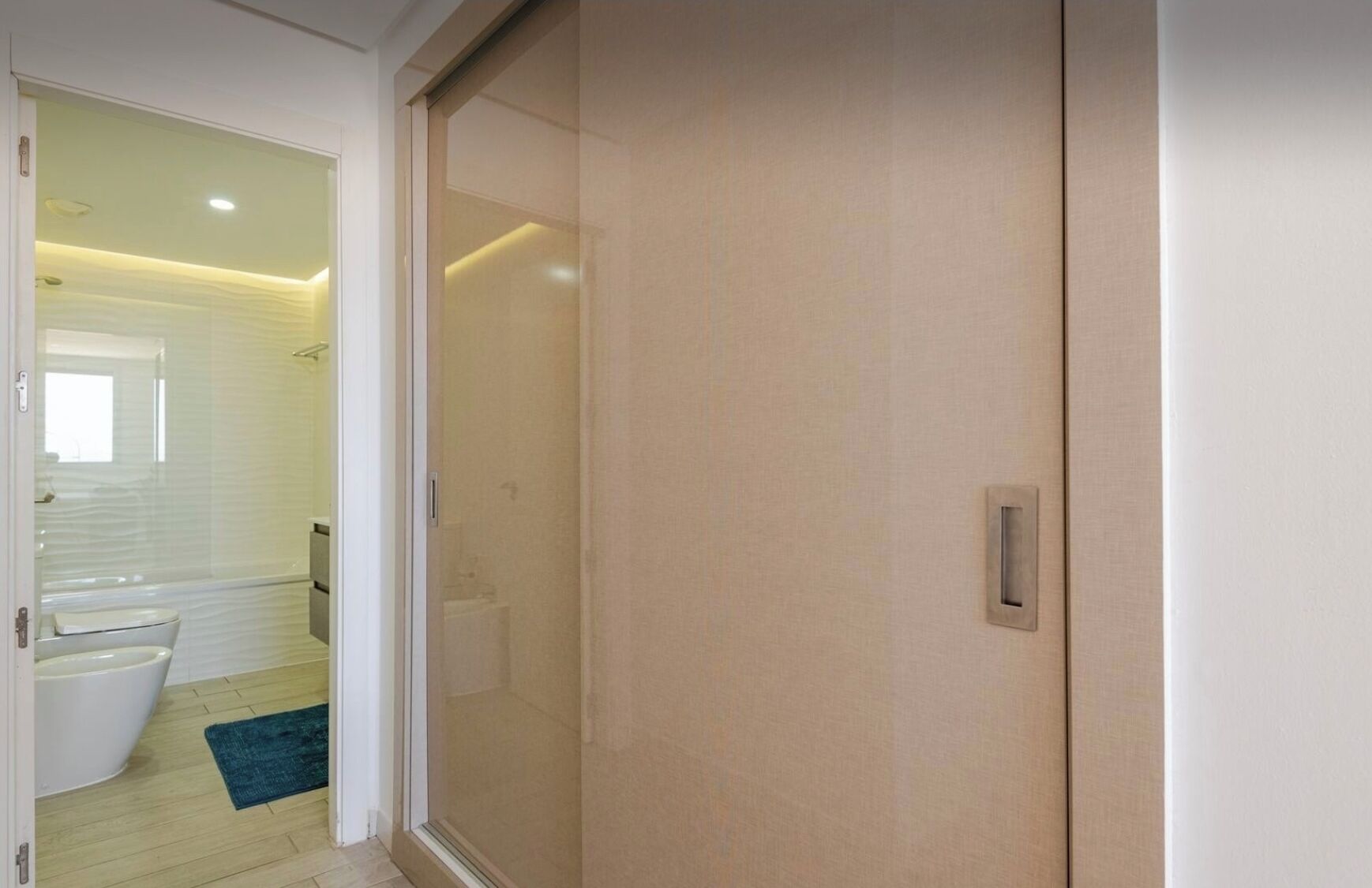 A modern bathroom with a toilet, sink, and shower.
