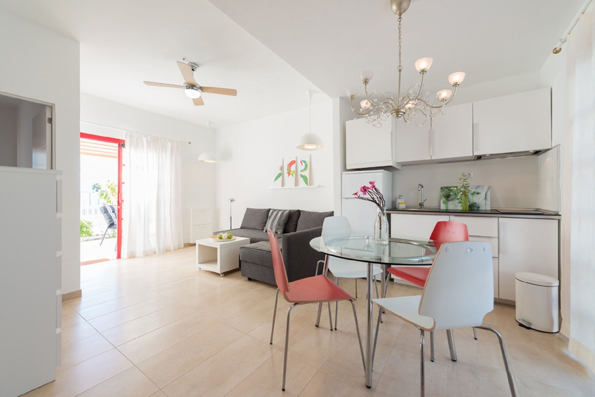 A modern living space with a dining area, kitchen, and a view of the outdoors.