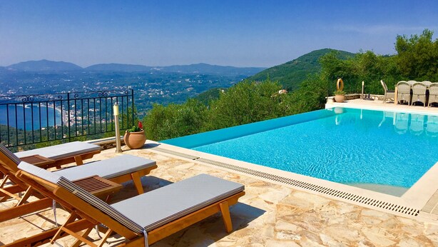 A swimming pool with lounge chairs and a view of the sea and mountains. - Prestige Villas |  SPARTILAS | Secluded Villa 15-20 mins walk to Taverna (Spartilas)
