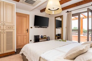 A bedroom with a bed, a TV, a wardrobe, and a balcony with a view. - Holiday Home La Verna with Pool (Skradin)