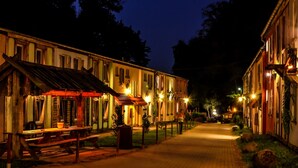 En smal gade kantet af traditionelle bygninger, hver med en unik arkitektur og oplyst af varm belysning.