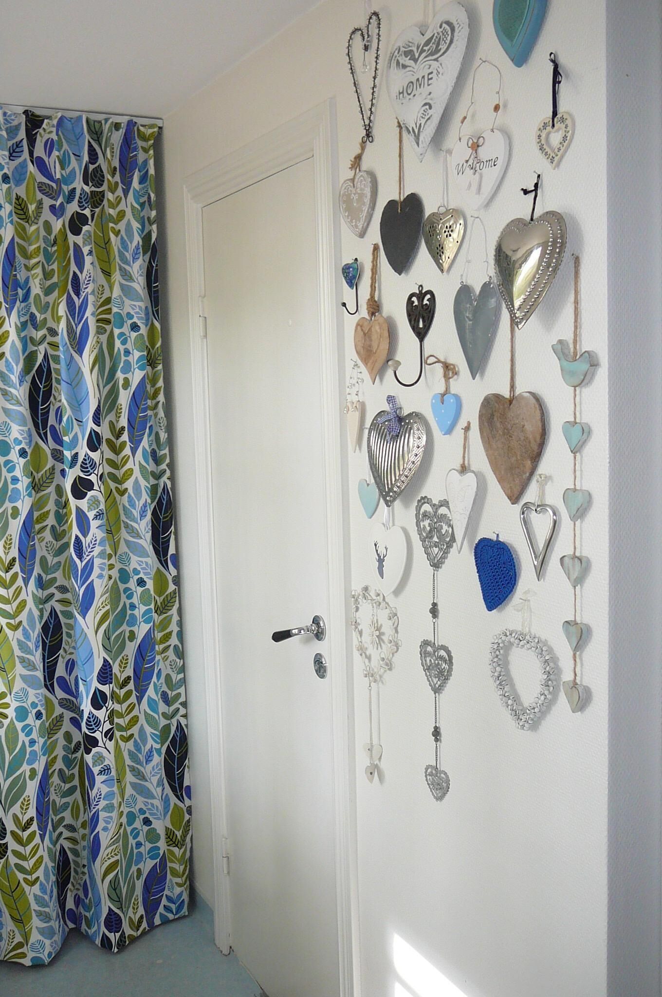 Una habitación con una puerta blanca y una pared decorada con varios adornos con forma de corazón.