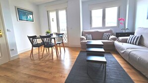 Ein Wohnzimmer mit einer Couch, einem Esstisch mit Stühlen und einem Couchtisch.