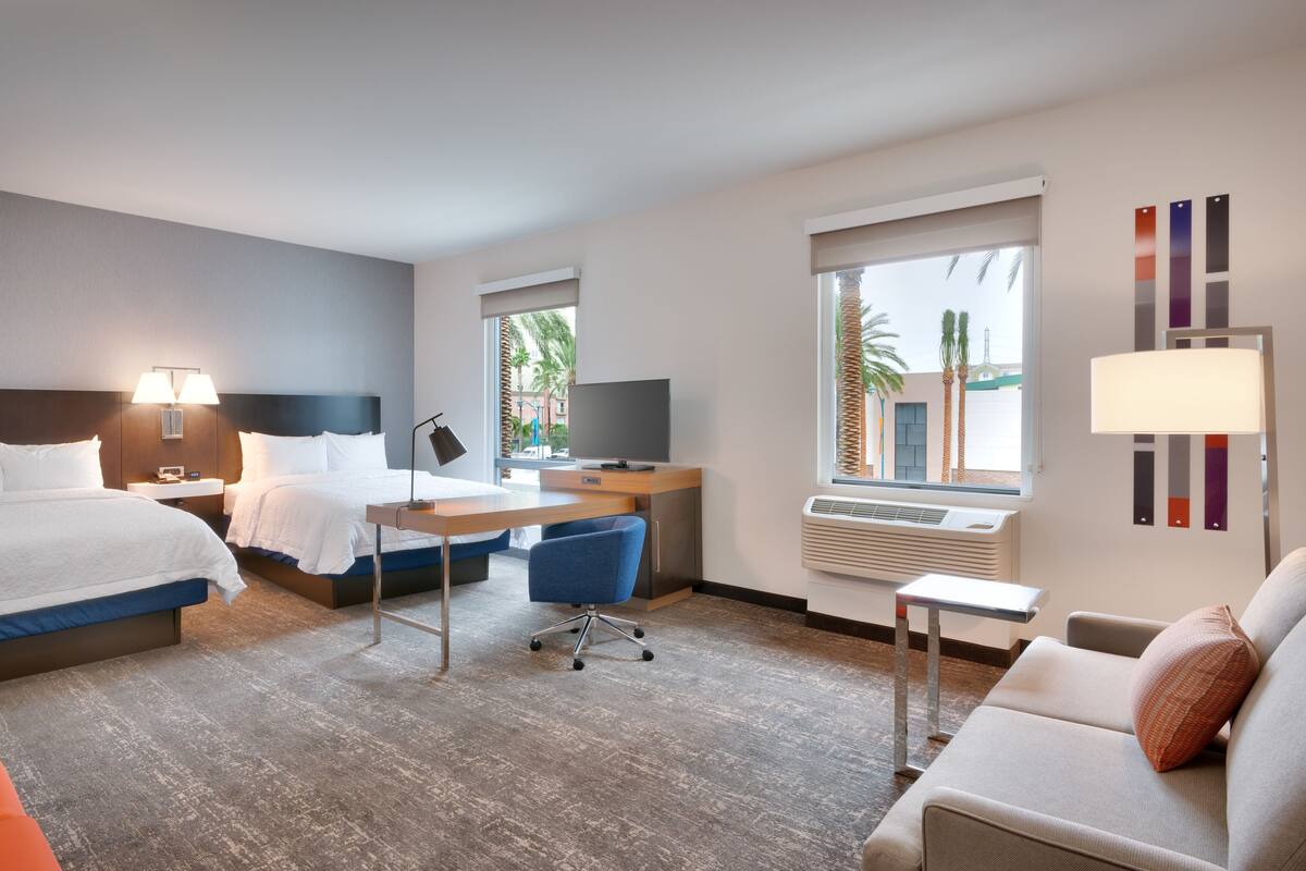 Une chambre d’hôtel avec un lit, un bureau, une chaise et un canapé.