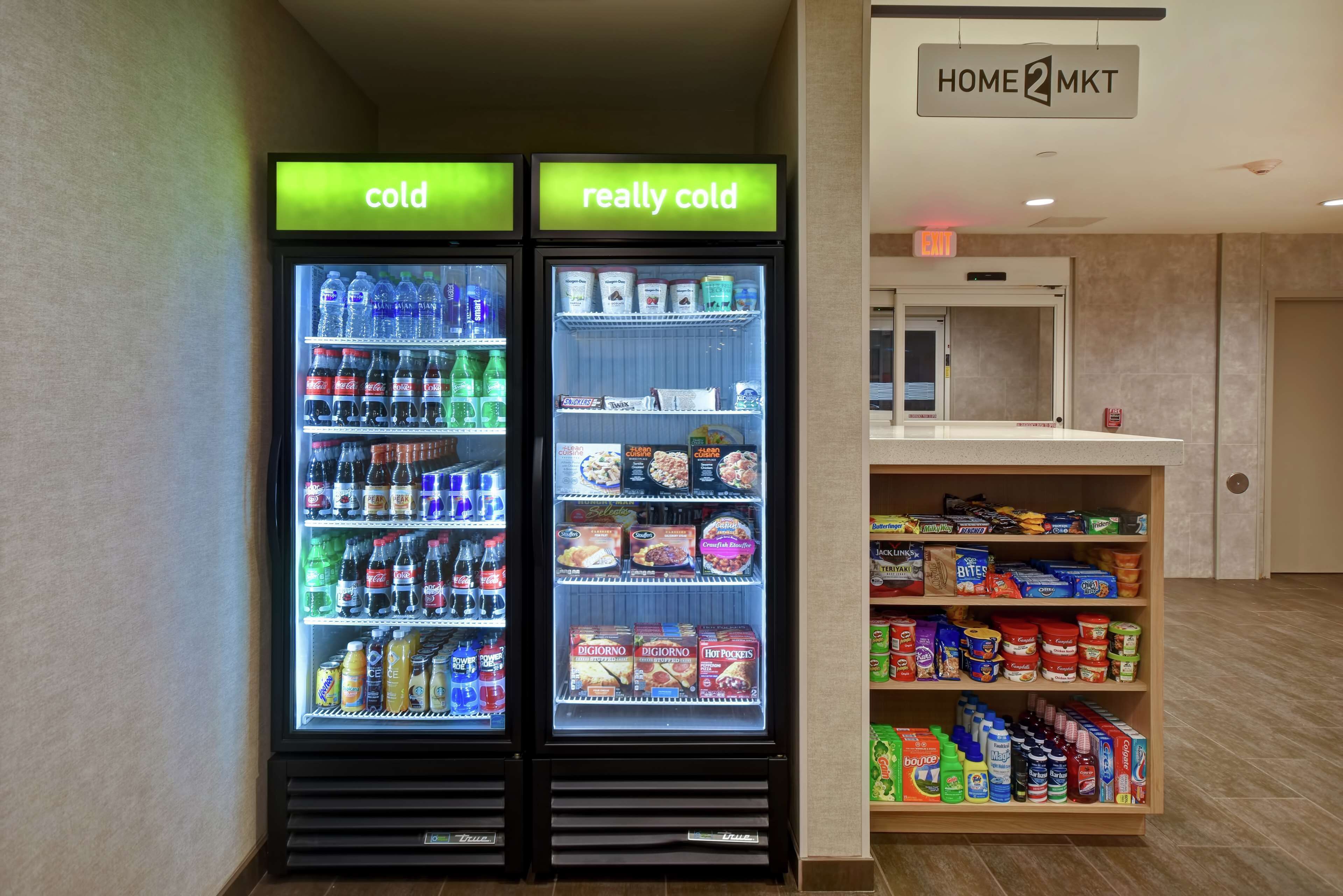 Two refrigerated beverage dispensers labeled "cold" and "really cold," and a shelf stocked with snacks and beverages.