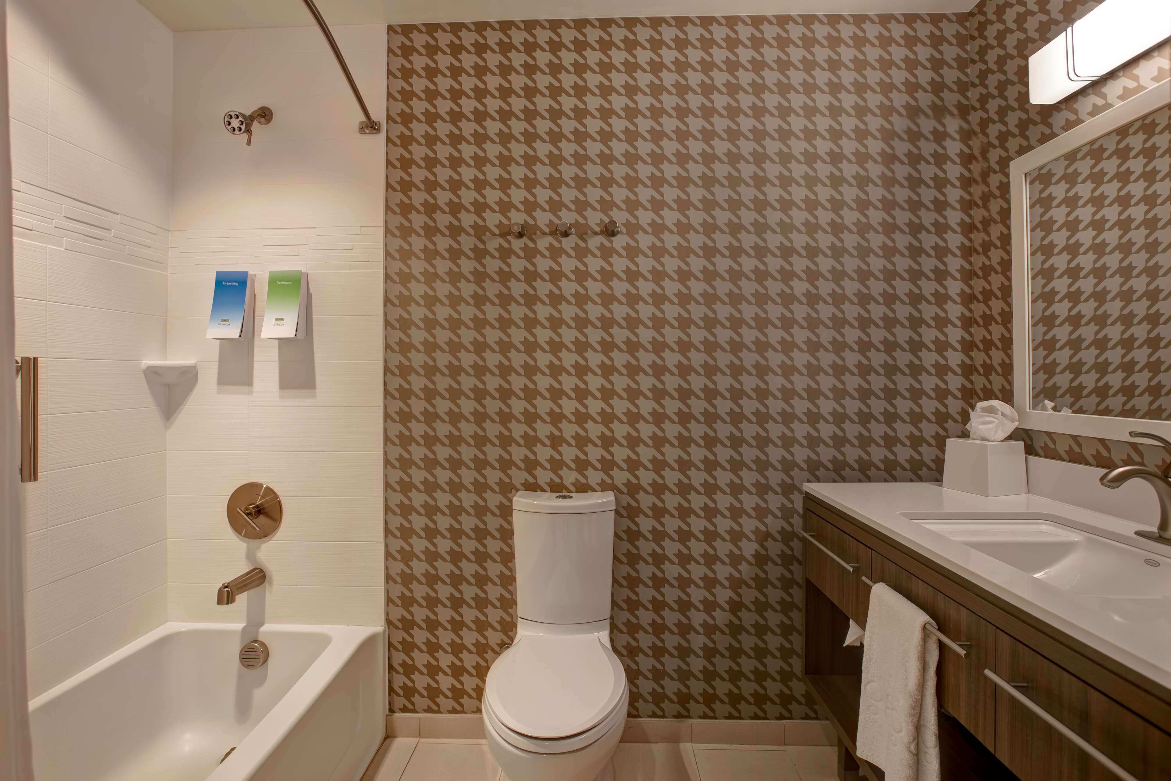 A bathroom with a white toilet, a bathtub, a sink, and a mirror.
