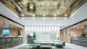 Un lobby moderno con zona de bar, asientos y un diseño de techo singular.