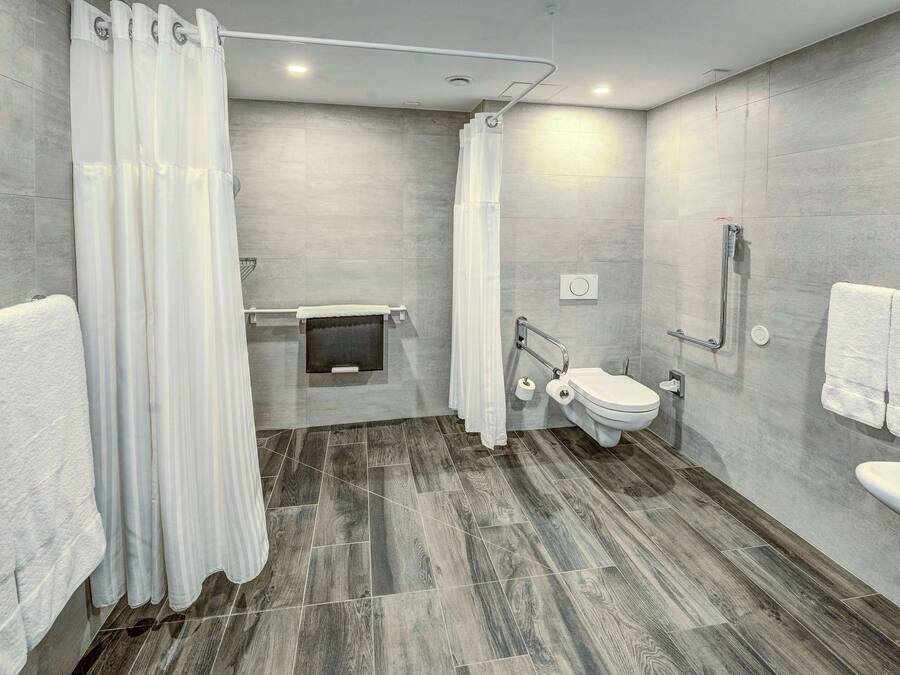 Une salle de bain moderne équipée d’une douche, de toilettes et d’un lavabo.