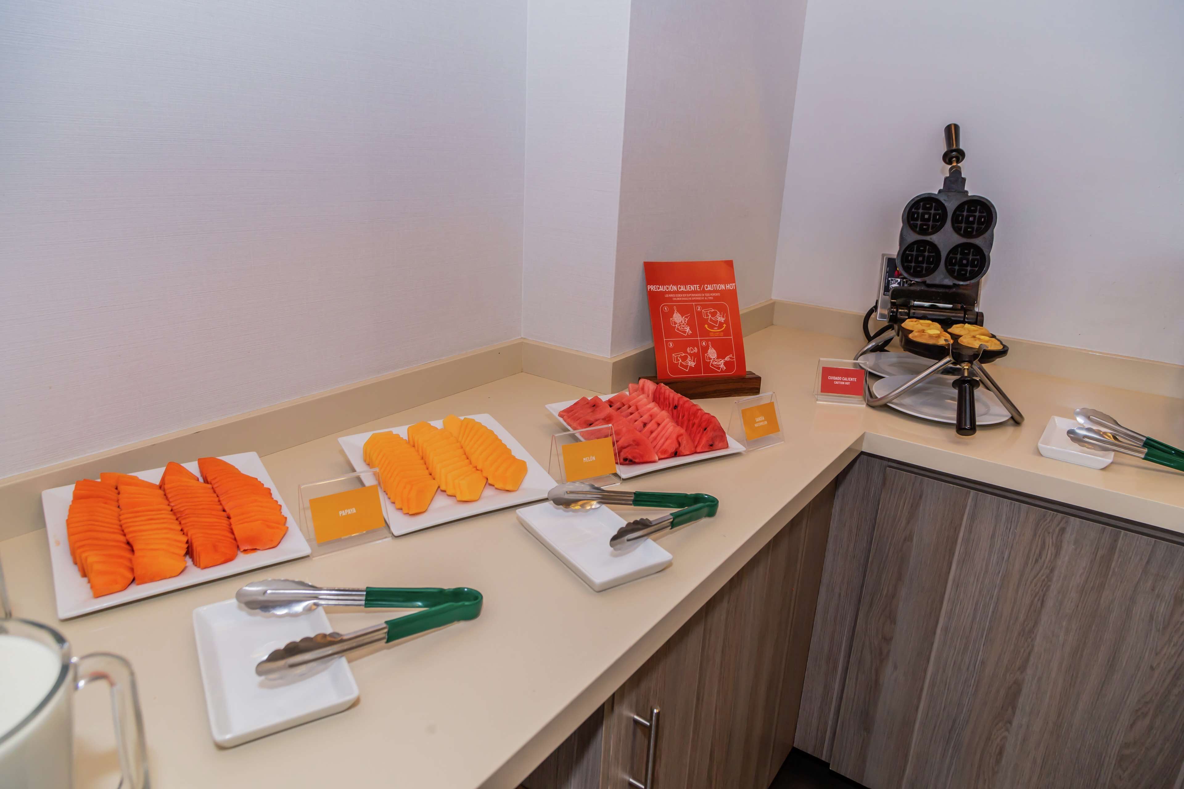 A buffet setup with various food items and serving utensils.