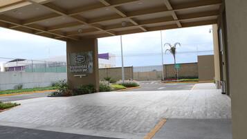 Entrada de un hotel con un letrero que dice "bienvenido a Hampton Inn".