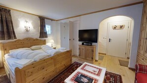 Un dormitorio con una cama de madera, un televisor y un armario.