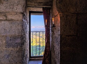 A stone-walled room with a window overlooking a landscape. - Medieval Tower experience with Panoramic Rooftop, San Gimignano (Italia)