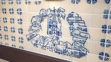 Parede com azulejos azuis e brancos com padrão geométrico.