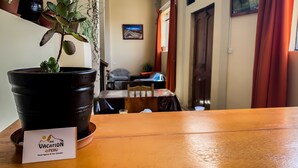 A reception area with a potted plant, a wooden reception desk, and a sign for 'Big Vacation Peru'. - Big Vacation Hostel (Cusco)
