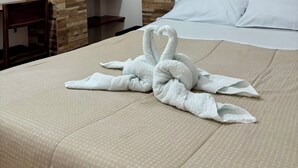 A hotel room with a bed, a wooden wall panel, a hanging coat rack, and a bedside table. - Big Vacation Hostel (Cusco)