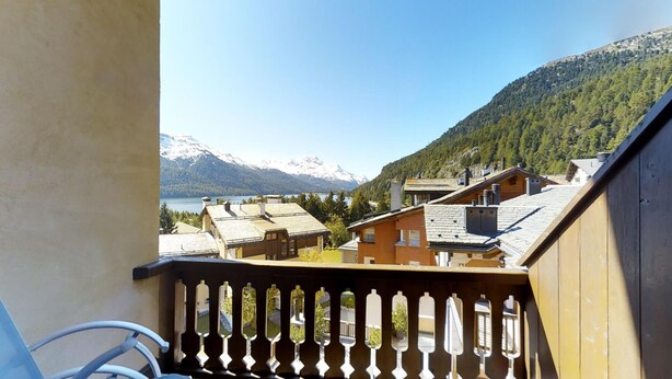 Un balcon avec vue sur une montagne et un lac.