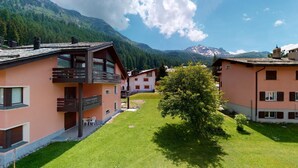 Ein modernes Hotel mit Innenhof, Balkonen und Bergblick.