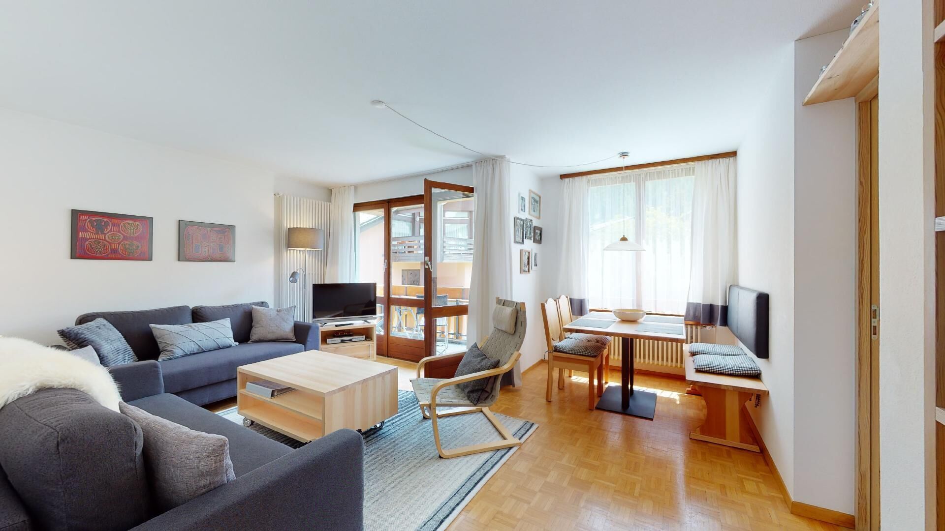 Un salon moderne comprenant un canapé, une table basse et un coin repas avec une table et des chaises.