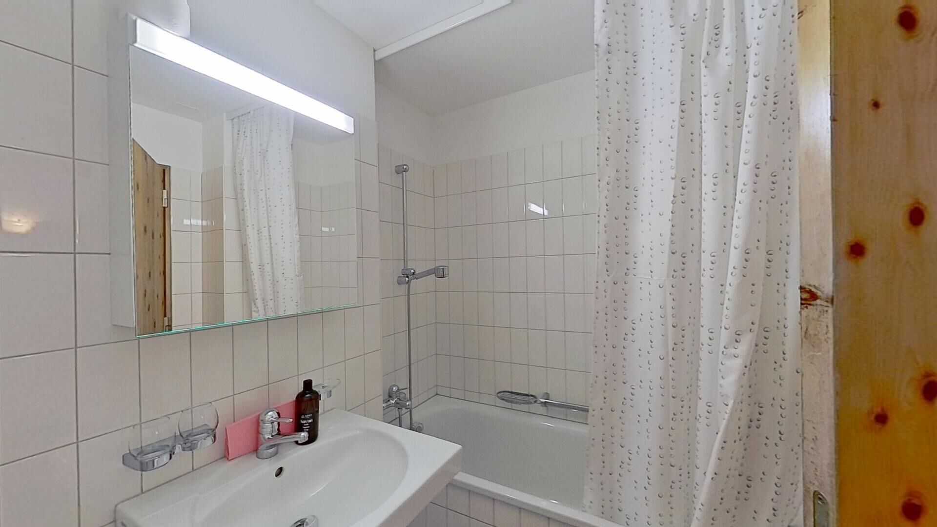 Ein Badezimmer mit Waschbecken, Spiegel und Badewanne.