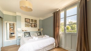 Een slaapkamer met een groot bed, een spiegel en prestaties in lijsten aan de muur.