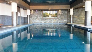A large indoor swimming pool with stone walls and a mural. - Ski-in/ski-out apartment, 2 bedrooms, covered parking included (Les Arcs 1800)