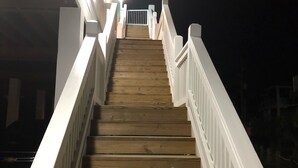 A wooden staircase with white railings leading to a higher level.