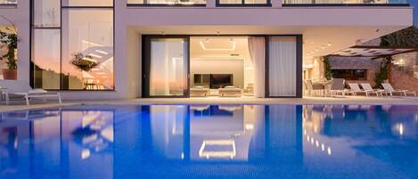 A modern two-story building with a swimming pool in the foreground.