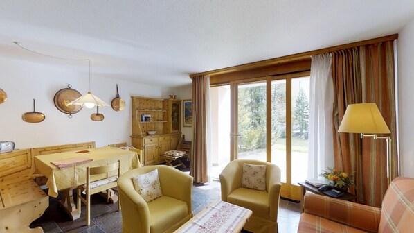 Une pièce chaleureuse comprenant une table à manger, deux fauteuils, un canapé et une lampe.