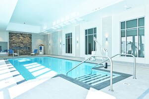 Una piscina techada, sillones reclinables de piscina