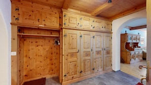 A wooden wardrobe with multiple compartments and a metal handle. - 5½-roomed apartment on the ground floor, 140m2. (Celerina/Schlarigna)