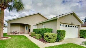 Einbungalow mit Garage, überdachter Terrasse und gepflegtem Garten.