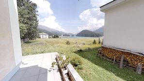 Ein Balkon mit Blick auf einen See, Berge und ein Gebäude in der Ferne.