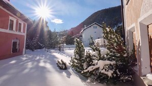 Eine schneebedeckte Straße mit Gebäuden und einem Berg im Hintergrund.
