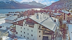A multi-story hotel with a ski slope and a lake view.