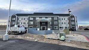 A multi-story hotel with a central entrance, a parking area, and construction equipment nearby. - Quality Inn Carlin (Carlin)
