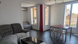 A modern living room with a sofa, a coffee table, and a dining area with chairs and a table. - 58m2 flat in ST Raphael-600 metres from the beach and train station-free parking (Saint-Raphaël)