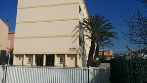 A multi-story building with a flat facade, a gated entrance, and a palm tree in the foreground. - 58m2 flat in ST Raphael-600 metres from the beach and train station-free parking (Saint-Raphaël)