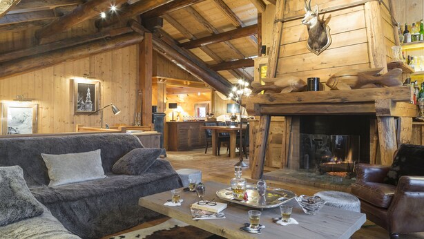 L’intérieur d’un chalet confortable, avec une cheminée, des meubles en cuir et un coin repas.