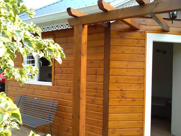 A wooden house with a covered porch, a window, and a bench. - DISCOVER MY CHARMING BUNGALOW WITH POOL (Le Gosier)