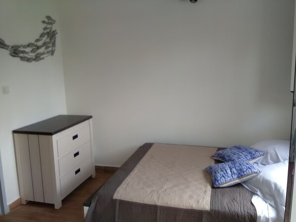 A bedroom with a bed, a bedside table with drawers, and a wall decoration. - DISCOVER MY CHARMING BUNGALOW WITH POOL (Le Gosier)