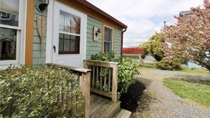 Ein zweistöckiges Haus mit Veranda, Briefkasten und einem kleinen Garten.