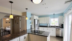 Eine moderne Küche mit weißen Schränken, Granit-Arbeitsplatten und Edelstahlgeräten.