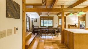 A wooden interior with a dining area, wooden beams, and a kitchen island. - 4,000 sqft Mt. Baker Ski Lodge, sleeps 21, walk to town, hot tub, fiber internet (Glacier)