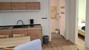 Un espacio habitable moderno y funcional, con kitchenette, comedor y dormitorio.